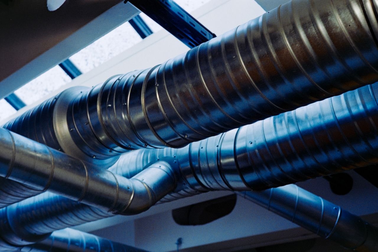 our-services-1 Close-up of a modern metallic ventilation system in an industrial setting.